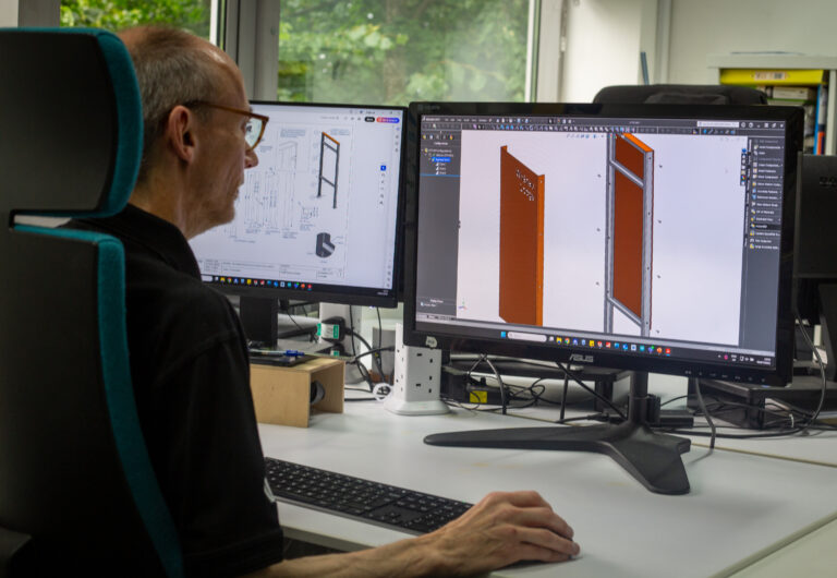 Leach employee designing product on the computer. Office space in the background.