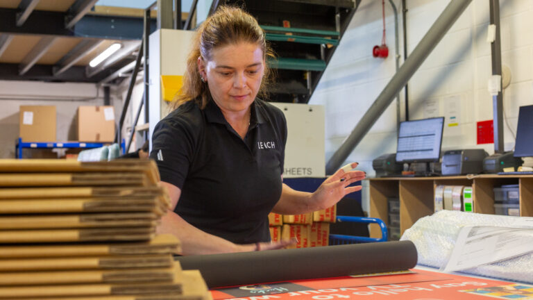 Leach employee rolling up a fabric graphic