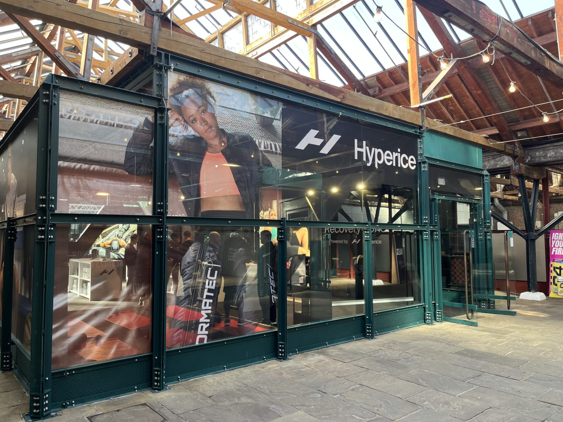 Hyperice exterior exhibition stand graphics at PerformX. It features a model in gymwear, there is also brand's black and white logo