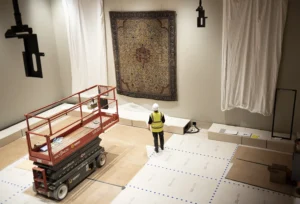 Inside of a museum construction, with a person in PPE installing graphics